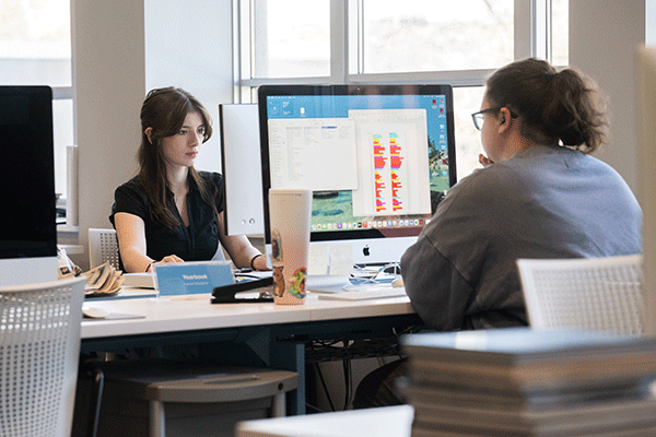 Two students working together at a computer in a digital media lab.
