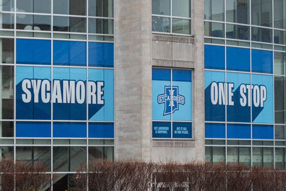 Indiana State University's Sycamore One Stop building with large blue window graphics displaying "Sycamore One Stop" and the Sycamores logo.