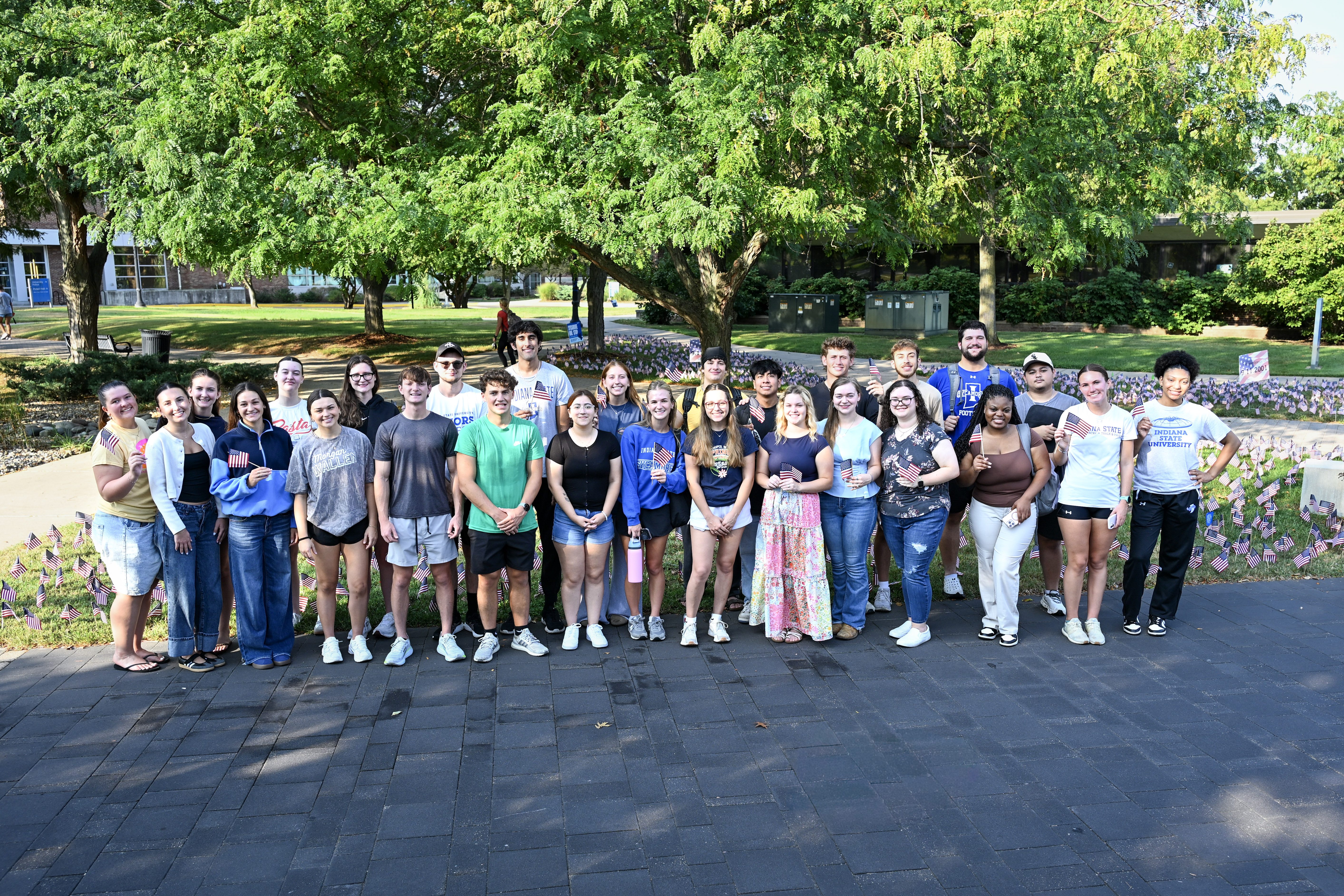 Group of ISU students standing in front of the flags they placed