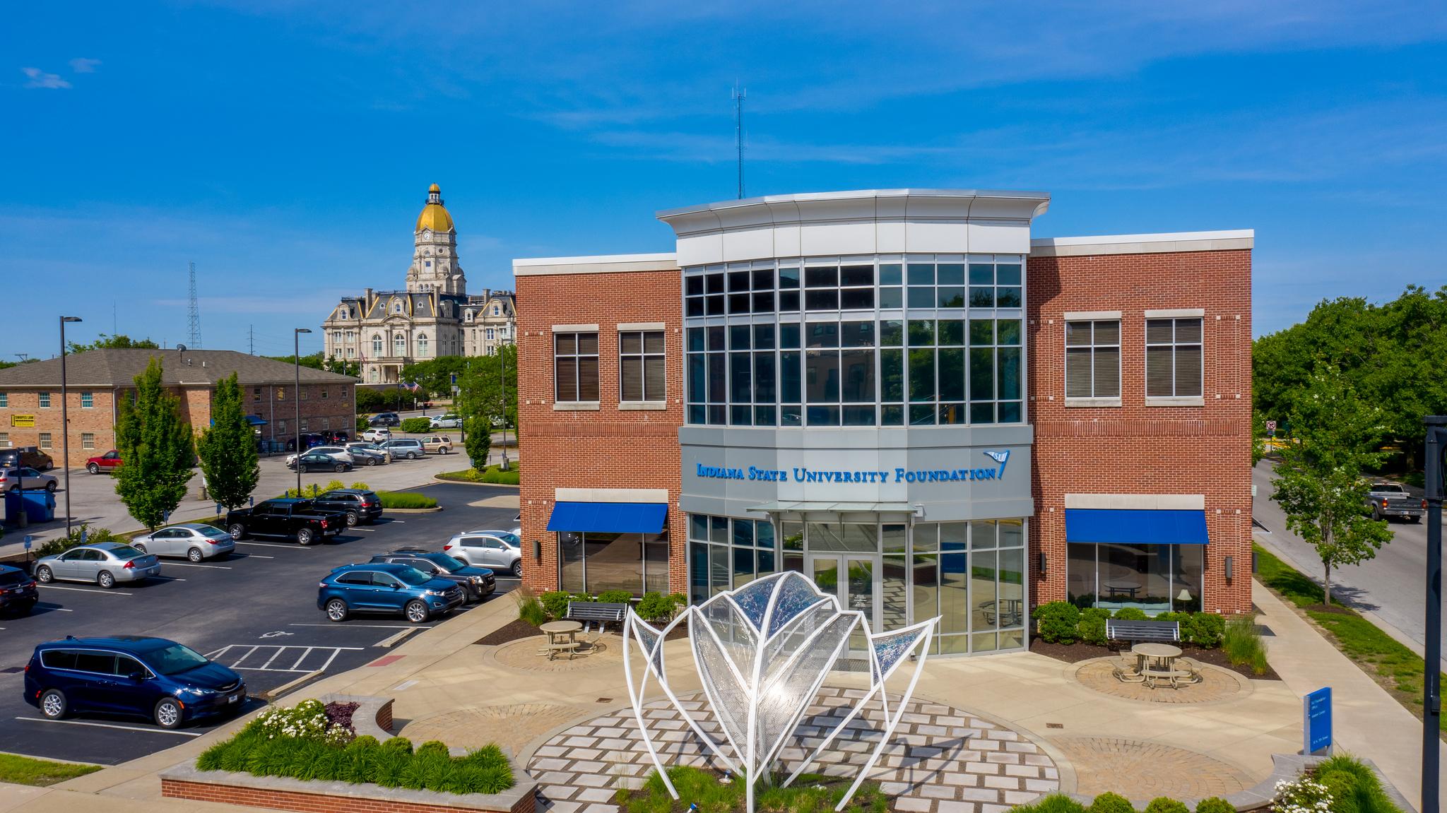 Indiana State University Foundation building with a large white metal and glass sculpture in front under a clear blue sky.