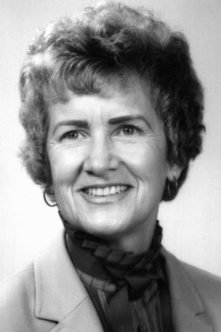 Black and white photo of a woman (Jan McCarthy) smiling. 